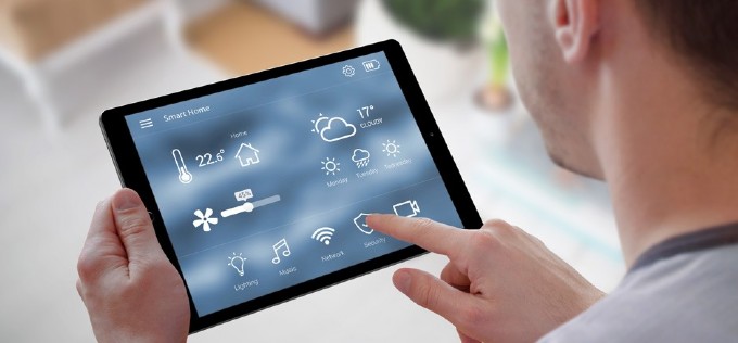 Mann steuert sein Haus über sein Tablet